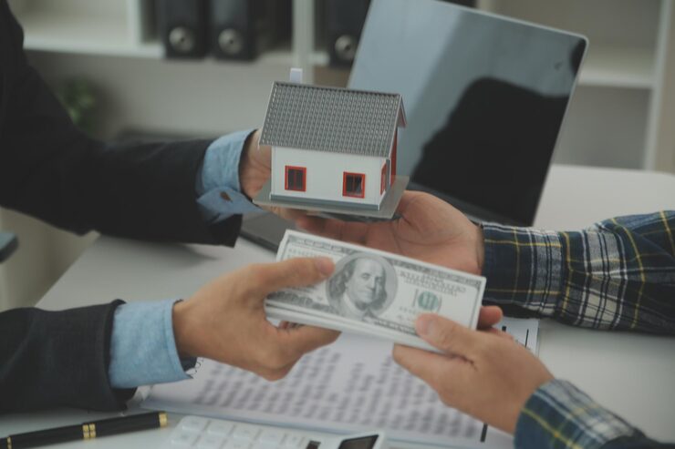 How much down payment for a house - buyer handing over cash for home purchase with house model