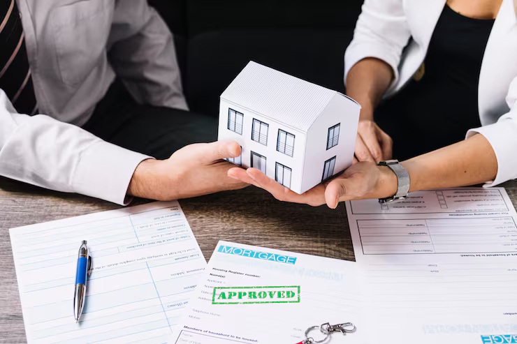 Alt text: pre approval vs pre qualification - agent and buyer holding house model over approved mortgage documents